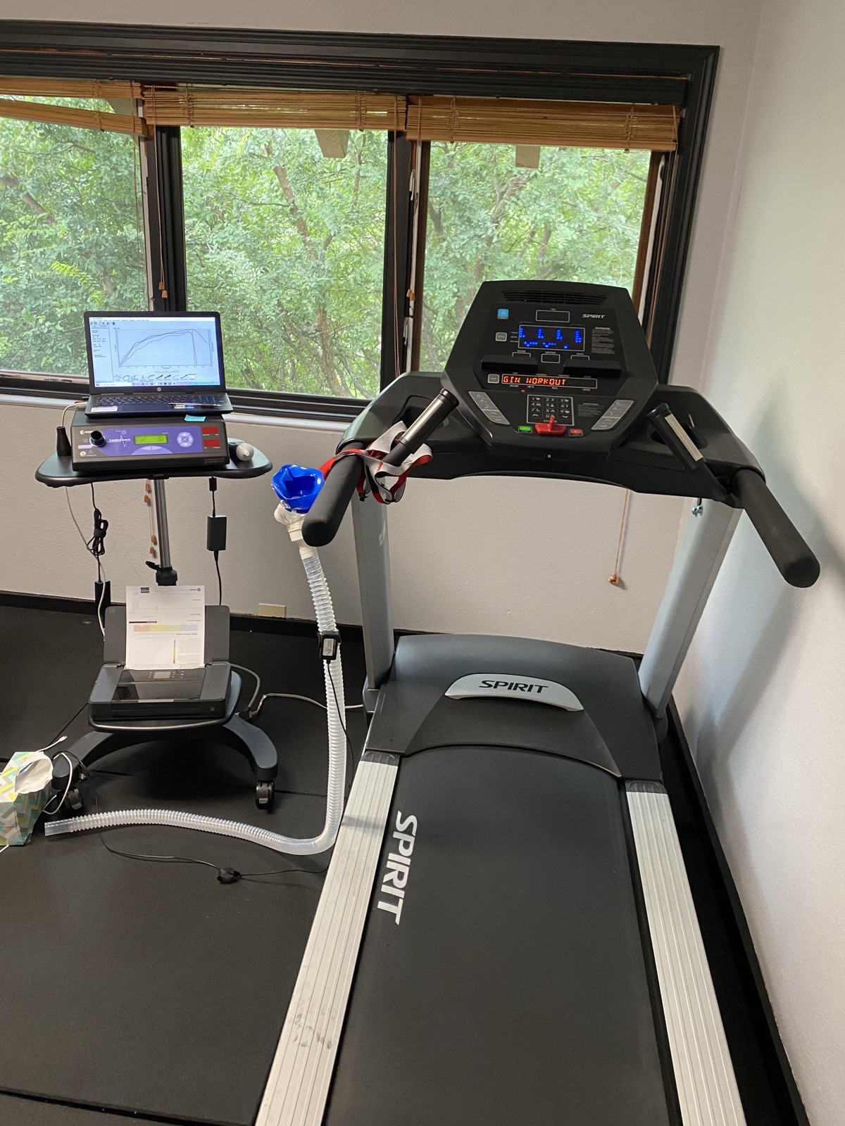 VO2 max testing lab with treadmill, breathing apparatus, and metabolic cart displaying results