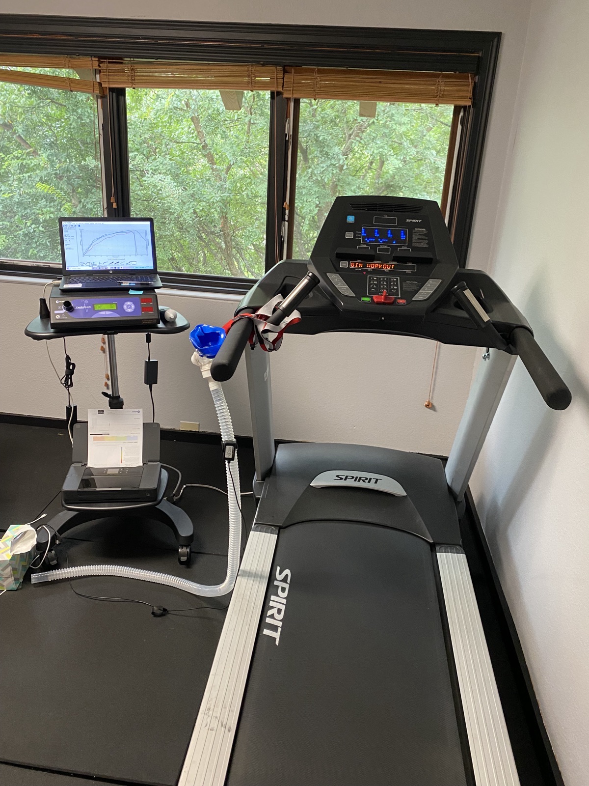 Person running on treadmill with VO2 max testing mask and metabolic cart equipment